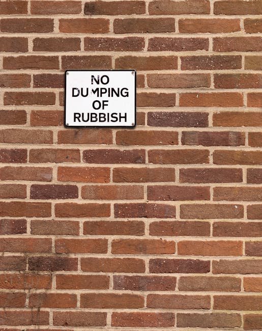 A large collection of mixed waste materials, including cardboard boxes, paper bags, plastic containers, and discarded packaging, piled on the sidewalk in front of a commercial property. The rubbish is